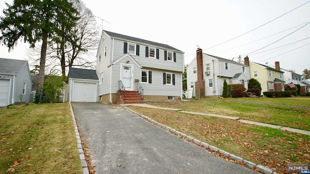 view of front of house featuring an outdoor structure, a front yard, and a garage