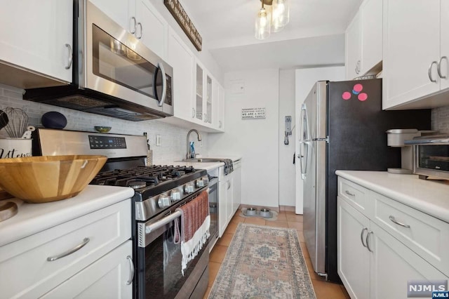 kitchen with appliances with stainless steel finishes, tasteful backsplash, and white cabinetry