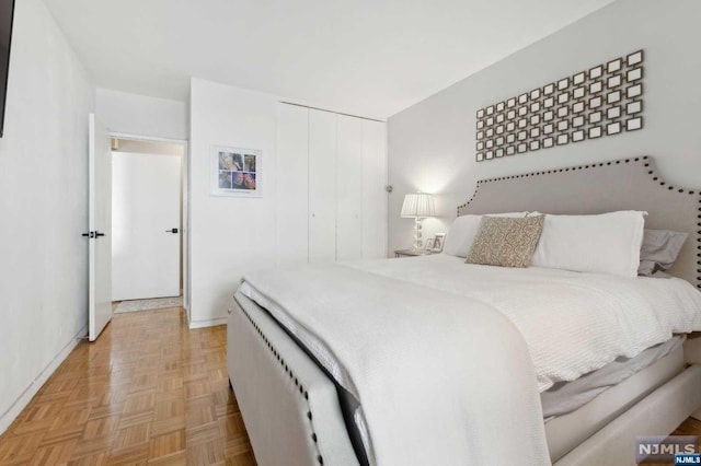 bedroom featuring a closet and light parquet flooring