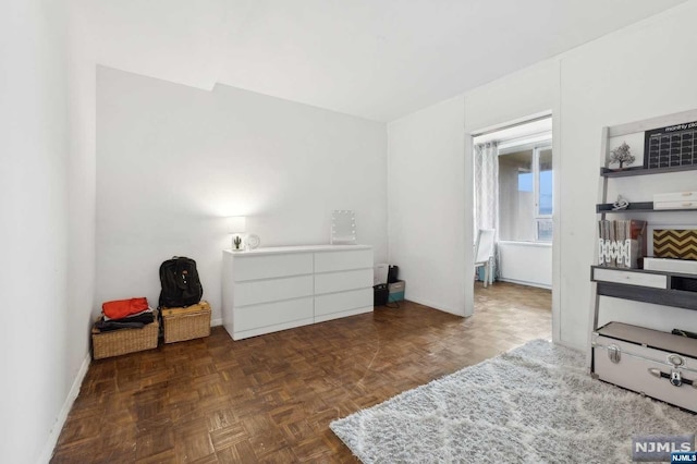 bedroom featuring dark parquet flooring