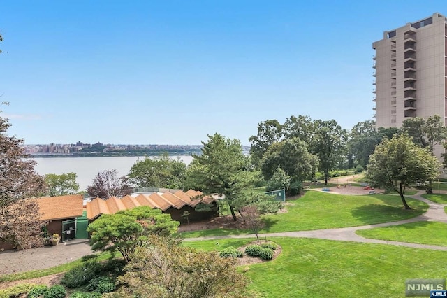 view of property's community with a lawn and a water view