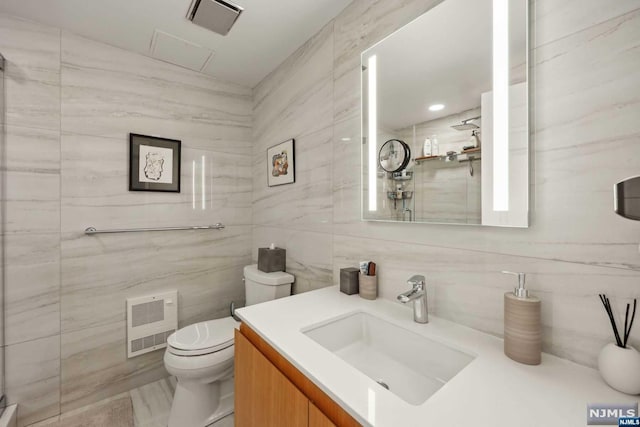 bathroom with vanity, tasteful backsplash, toilet, and tile walls