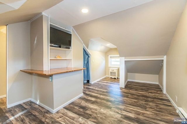 additional living space featuring dark hardwood / wood-style flooring and vaulted ceiling