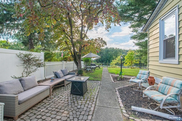 view of patio featuring an outdoor living space with a fire pit