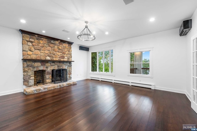 unfurnished living room featuring a wall mounted air conditioner, a stone fireplace, a baseboard radiator, dark hardwood / wood-style flooring, and a chandelier