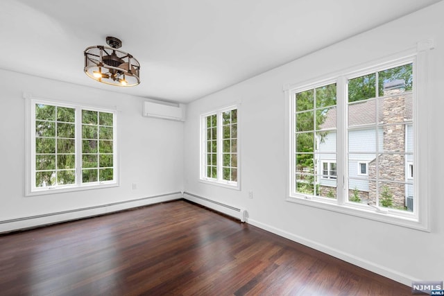 spare room featuring a wall mounted AC, plenty of natural light, and dark wood-type flooring