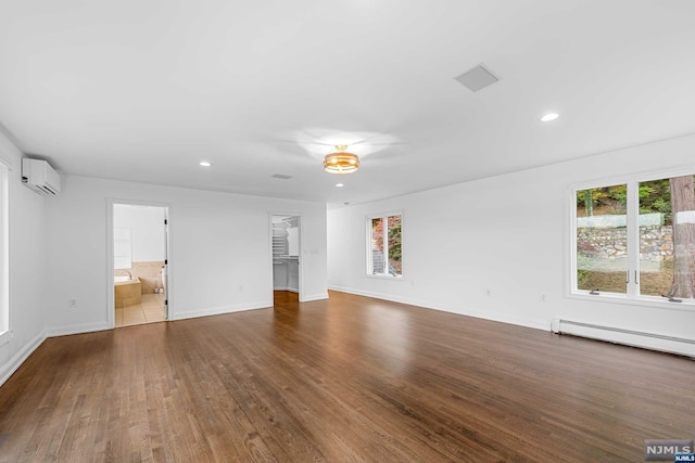 unfurnished living room with a wall mounted air conditioner and dark hardwood / wood-style flooring