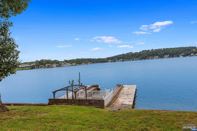 view of dock with a water view and a yard