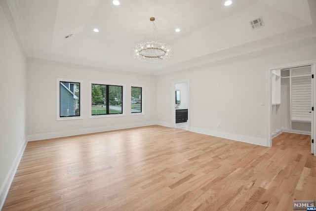 unfurnished living room featuring a chandelier and light wood-type flooring