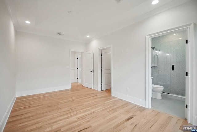 unfurnished bedroom featuring light wood-type flooring and connected bathroom