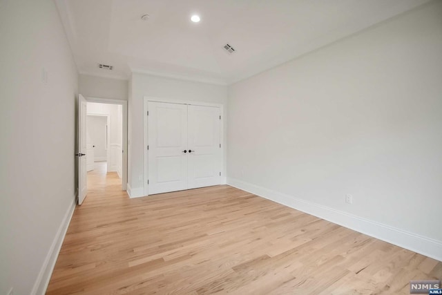 unfurnished bedroom with light hardwood / wood-style floors and a closet