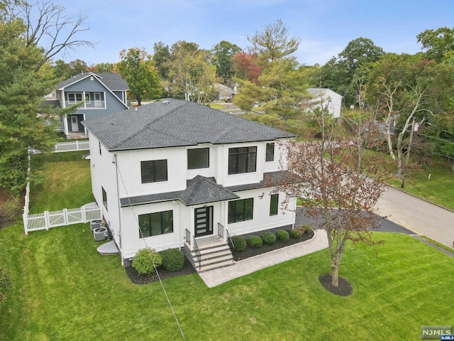 view of front facade with a front yard and central AC