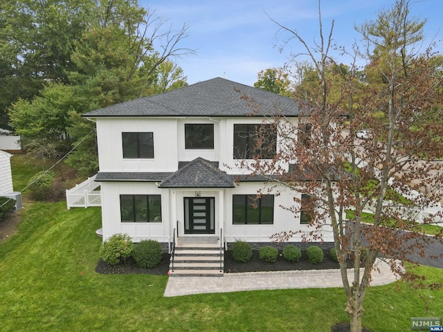 modern farmhouse style home with a front lawn