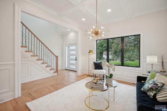 living room with beam ceiling, coffered ceiling, and a notable chandelier