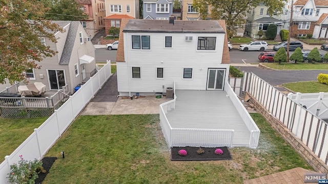 back of property with a lawn, central AC unit, and a wooden deck