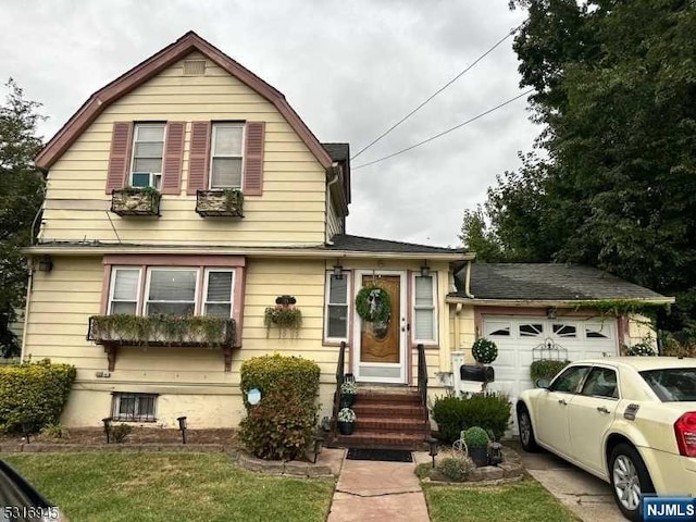 view of front of home with a front yard and a garage