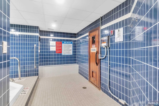 bathroom featuring a tile shower and tile walls