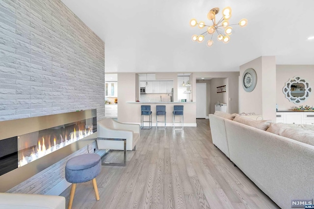 living room with an inviting chandelier and light hardwood / wood-style flooring