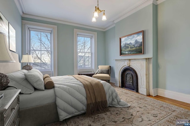 bedroom featuring light hardwood / wood-style floors, ornamental molding, radiator heating unit, and a chandelier