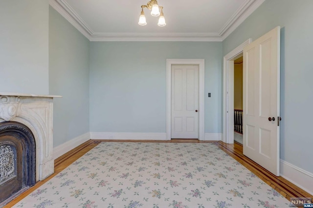 unfurnished living room featuring wood-type flooring, crown molding, and a notable chandelier