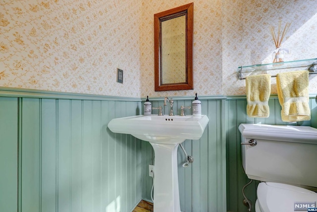 bathroom with wood walls and toilet