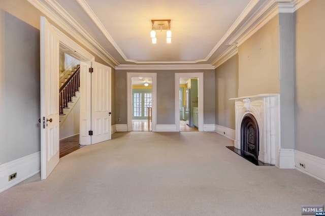 unfurnished living room featuring french doors, light colored carpet, and crown molding