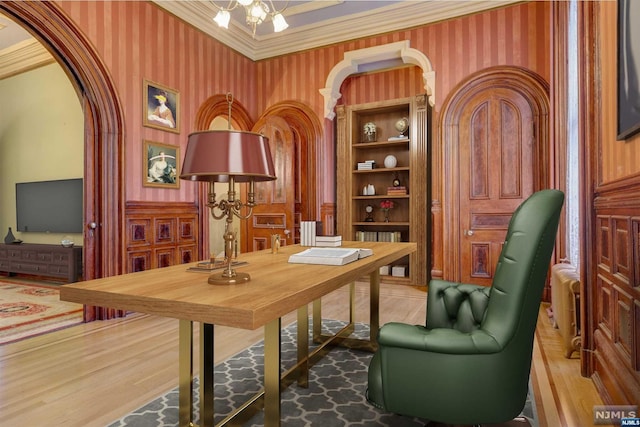 office space featuring wood-type flooring, an inviting chandelier, and ornamental molding