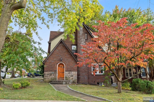 english style home featuring a front yard