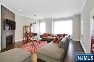 living room featuring a large fireplace, dark hardwood / wood-style floors, and crown molding