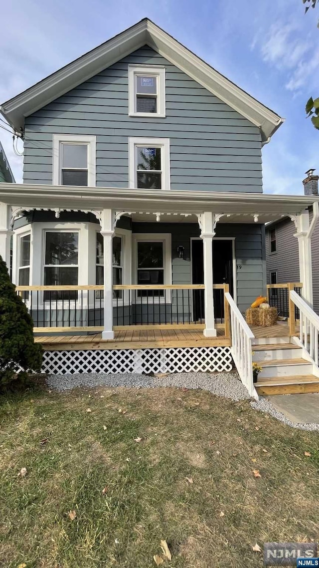 view of front of home with a porch and a front lawn