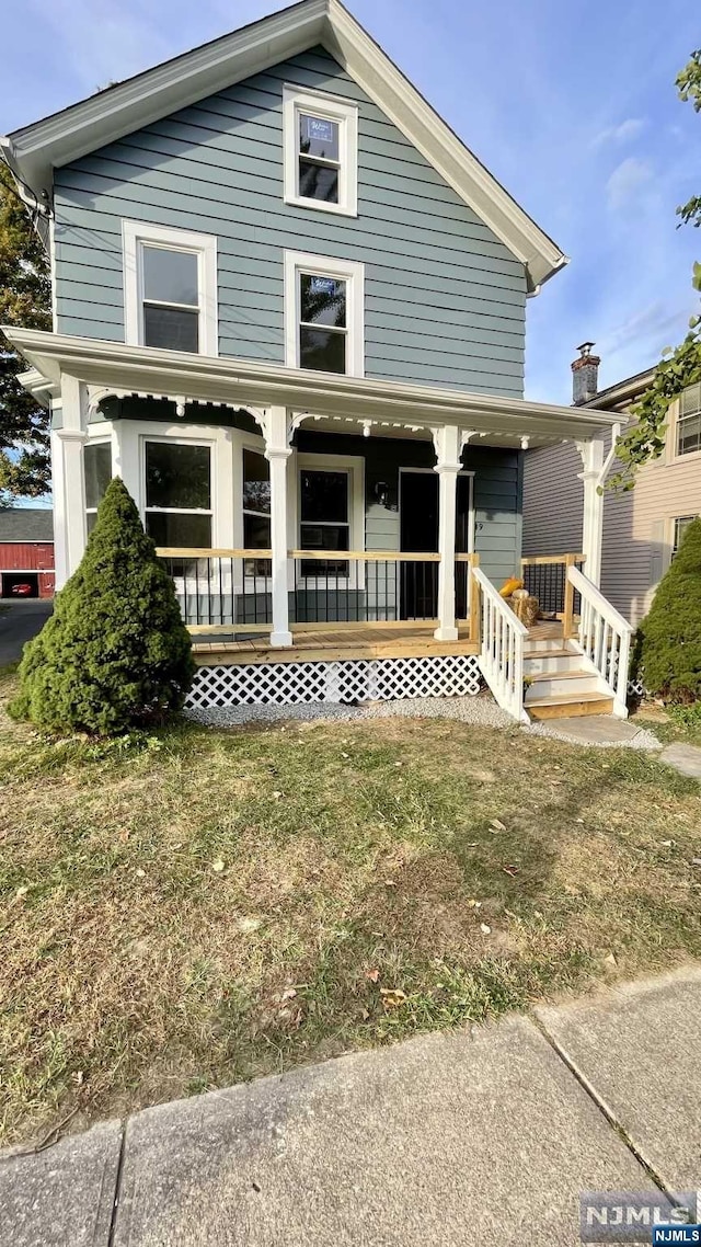 view of front of house with covered porch and a front yard