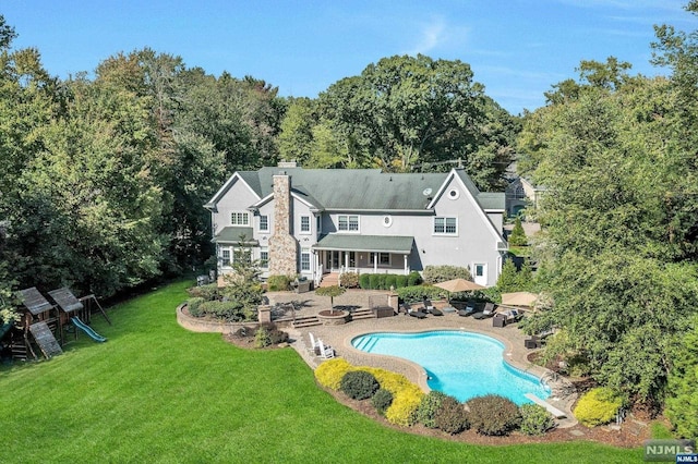 view of swimming pool with a fire pit, a playground, a patio, and a lawn