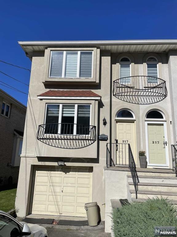 view of front of home featuring a garage and a balcony