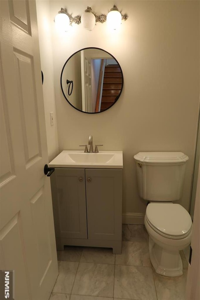 bathroom featuring tile patterned floors, vanity, and toilet