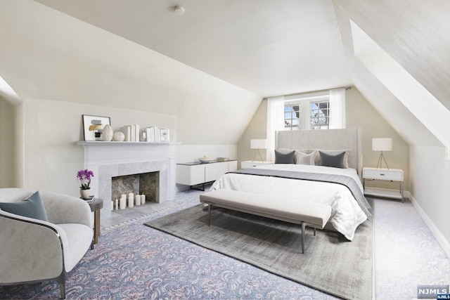 carpeted bedroom featuring a tiled fireplace and vaulted ceiling