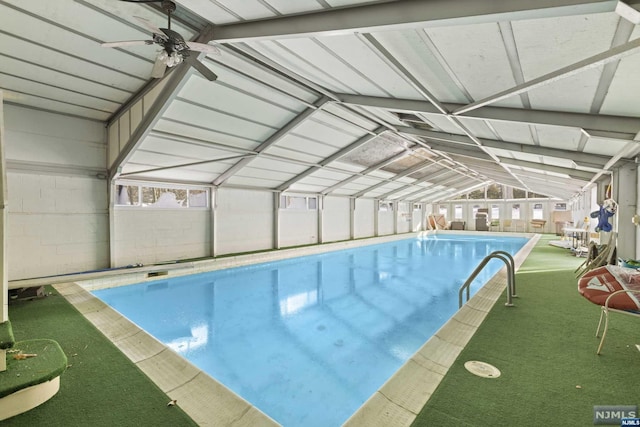 view of swimming pool with glass enclosure and ceiling fan