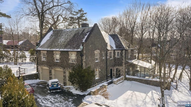 view of snow covered exterior featuring a garage