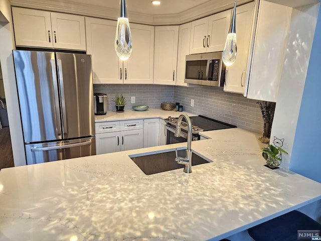 kitchen with sink, light stone counters, decorative backsplash, white cabinets, and appliances with stainless steel finishes