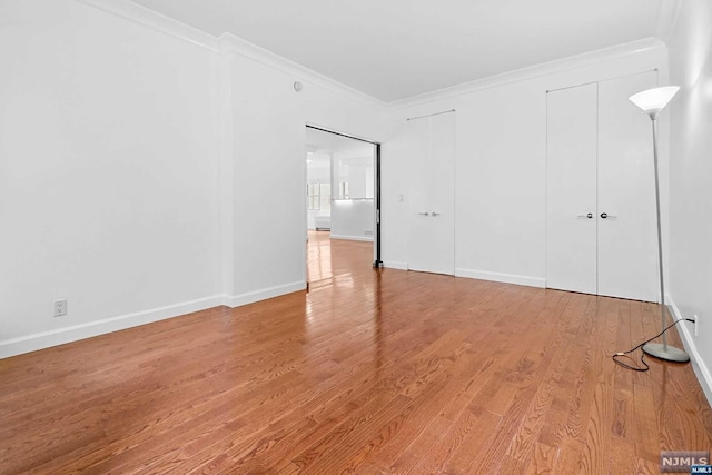 unfurnished bedroom featuring wood-type flooring and crown molding