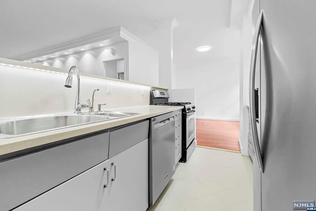 kitchen with sink, light tile patterned flooring, and stainless steel appliances