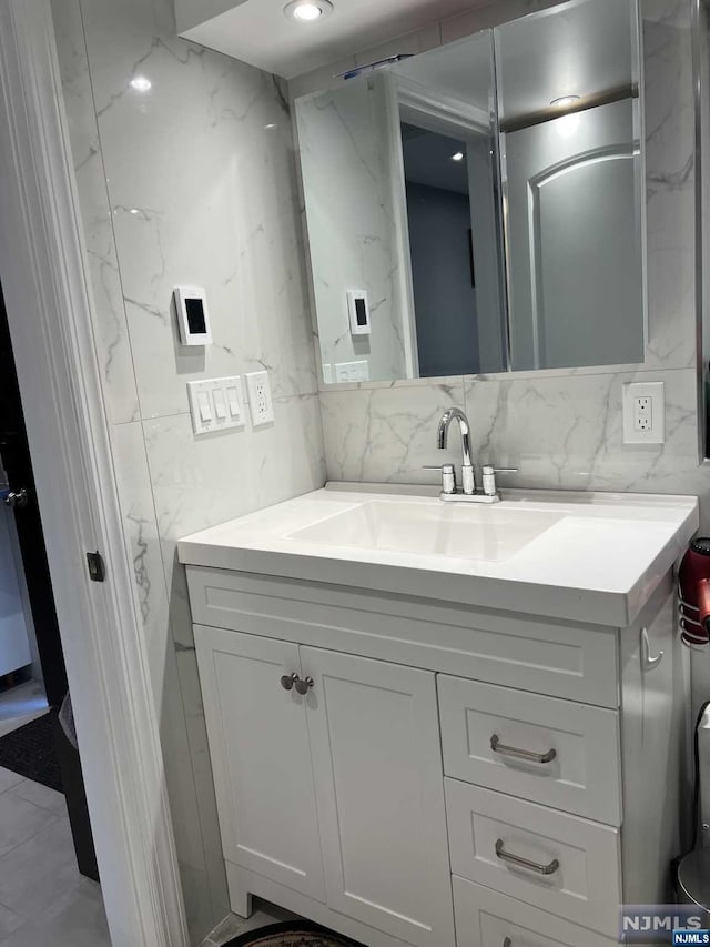 bathroom with vanity and tasteful backsplash