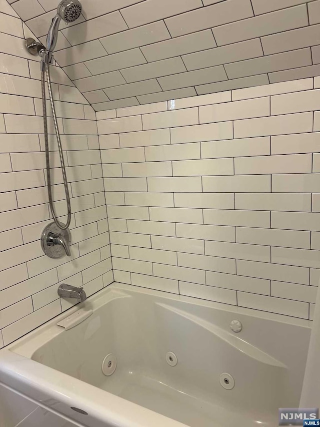 bathroom featuring tiled shower / bath