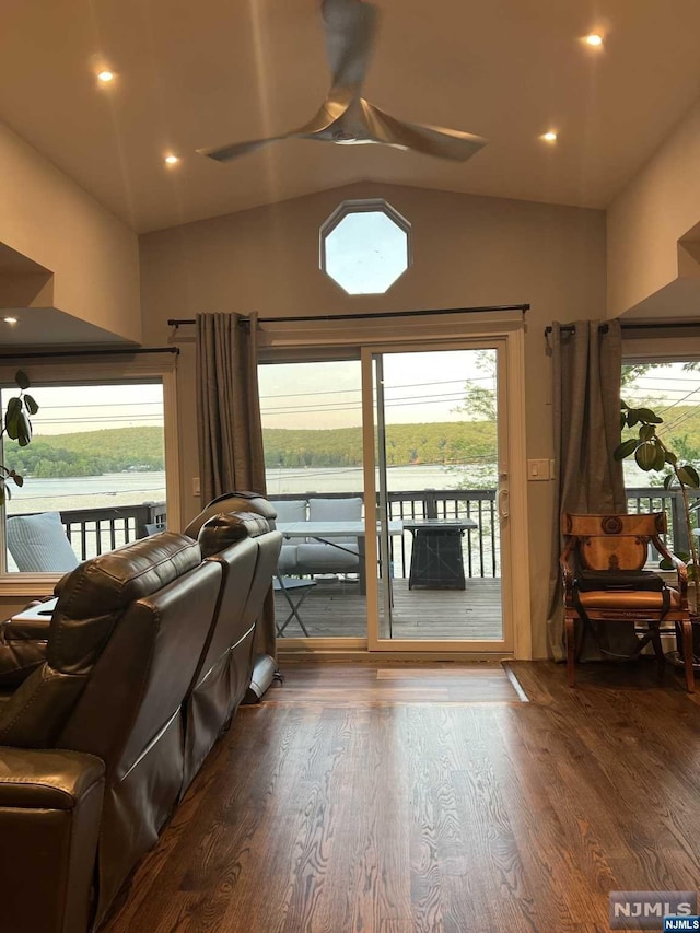 interior space with hardwood / wood-style floors, a water view, vaulted ceiling, and a healthy amount of sunlight