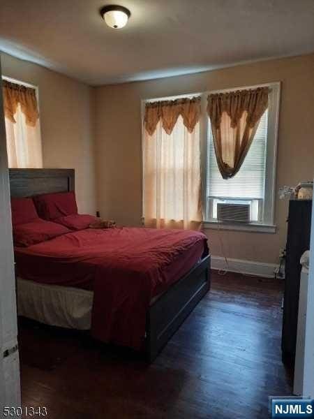 bedroom featuring dark hardwood / wood-style floors and cooling unit