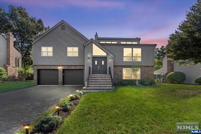 view of front of house with a garage and a lawn