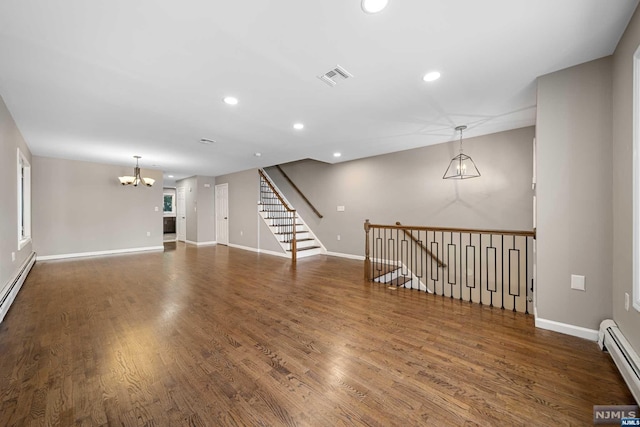 unfurnished living room with dark hardwood / wood-style flooring, a baseboard radiator, and a notable chandelier