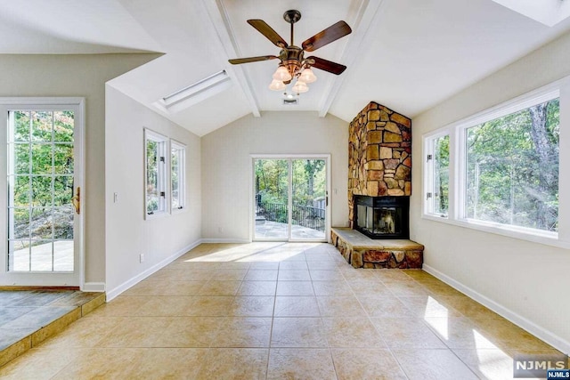 unfurnished living room with vaulted ceiling with beams, ceiling fan, a fireplace, and light tile patterned flooring