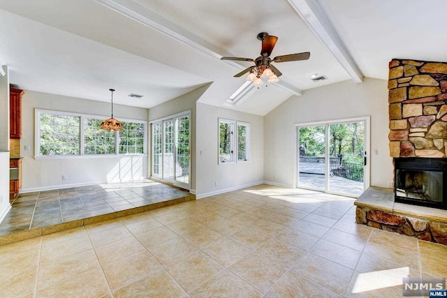 unfurnished living room with a fireplace, vaulted ceiling with beams, a wealth of natural light, and ceiling fan