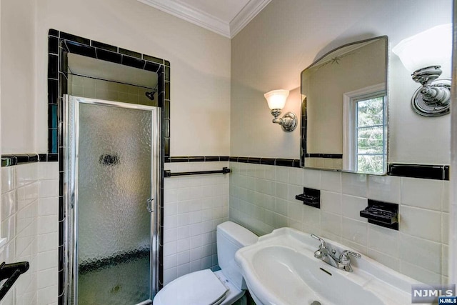 bathroom featuring sink, toilet, an enclosed shower, and tile walls