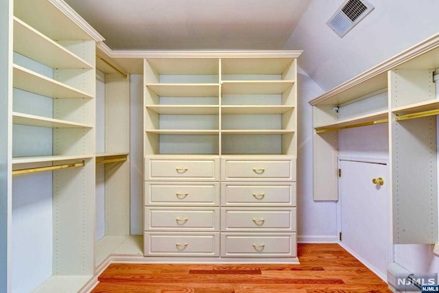 spacious closet with vaulted ceiling and light hardwood / wood-style flooring